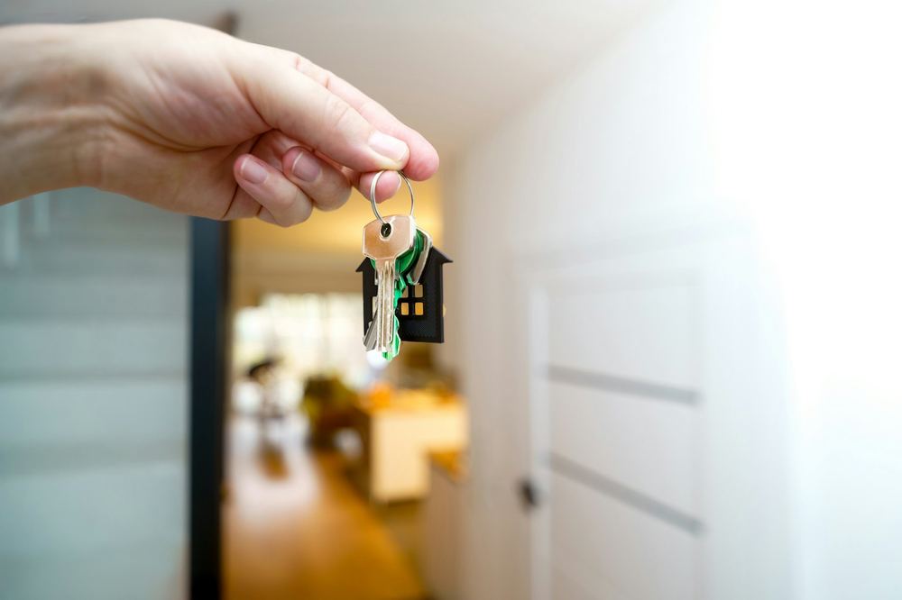 Hand die huissleutels overhandigt in een woning